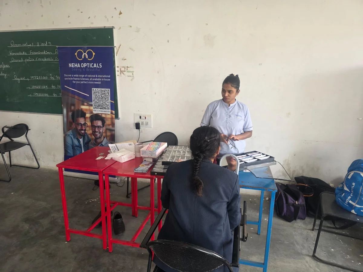 Optical assistant helping a community member select suitable spectacle frames during an eye camp