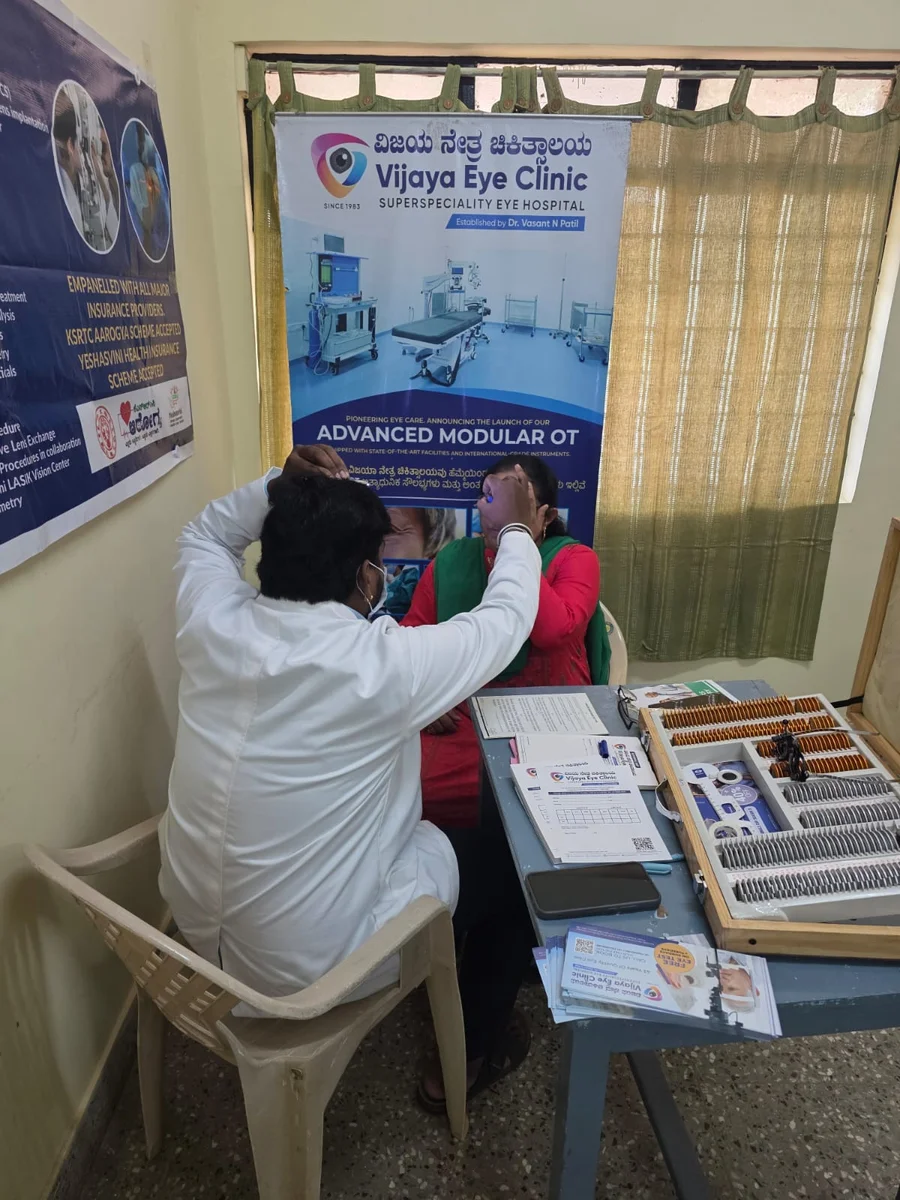 Examiner performing preliminary eye screening during an outreach vision camp