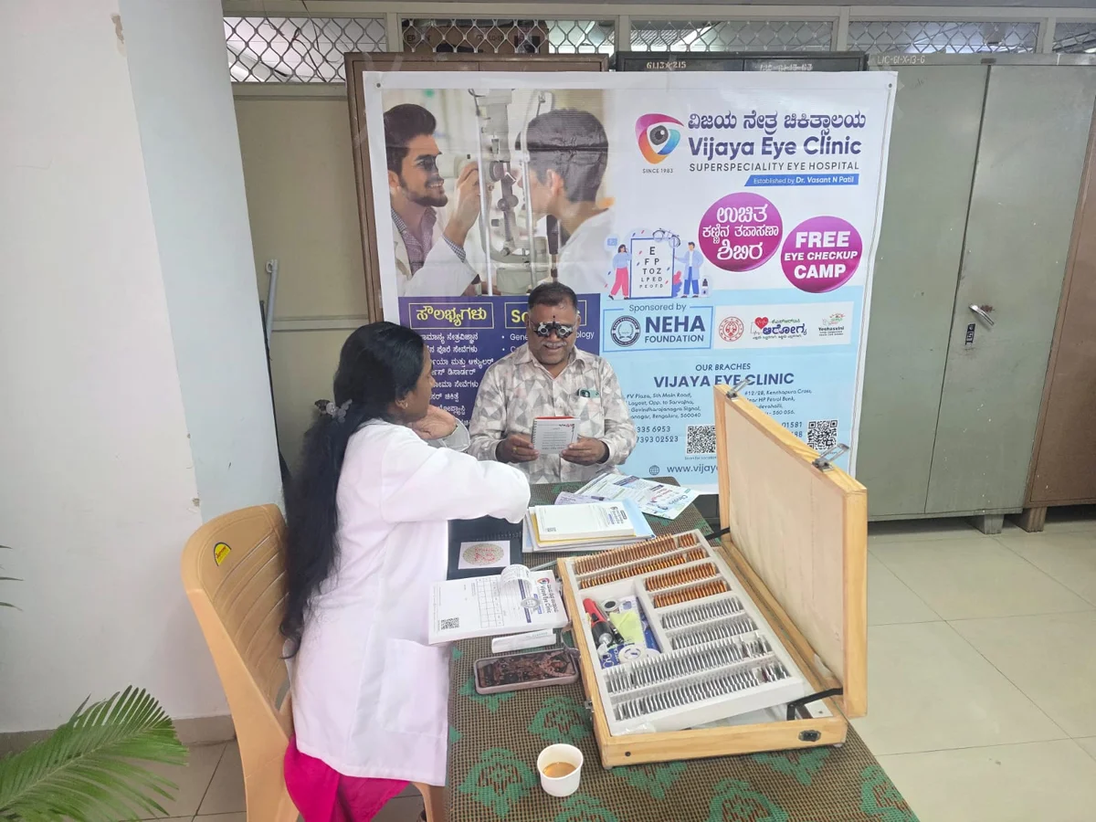 Community member reading a near-vision test card during an eye-screening camp sponsored by Neha Foundation